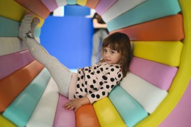 Child playing in colorful tunnel.
